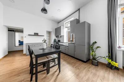 a kitchen with a black table and chairs in a room at Spacious and Bright Lukiskiu Square Apartment in Vilnius