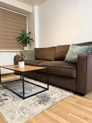 a living room with a brown couch and a coffee table at Premium 1-Bedroom Apartment in Vilnius Center with Self Check-in in Vilnius