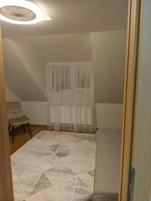 a room with a bed and a ceiling with a window at Cozy City Attic in Šiauliai
