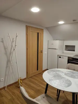 a small kitchen with a table and a table and chairs at Cozy City Attic in Šiauliai