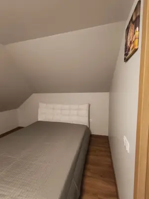 a small bedroom with a bed in a attic at Cozy City Attic in Šiauliai