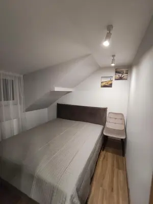 a small bedroom with a bed and a chair at Cozy City Attic in Šiauliai