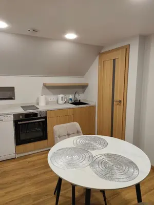 a kitchen with a white table in a room at Cozy City Attic in Šiauliai