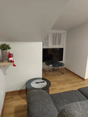 a living room with a couch and a table at Cozy City Attic in Šiauliai