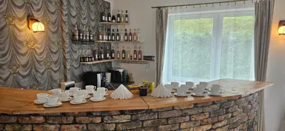 a bar with white cups and bottles of wine at Šaltenių pašvaistė