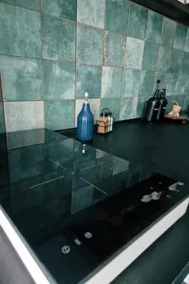 a bathroom with a counter with a blue vase on it at Wolfinn Comfort Apartment Siauliai Center in Šiauliai