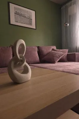 a sculpture of a snake sitting on top of a bed at Wolfinn Comfort Apartment Siauliai Center in Šiauliai