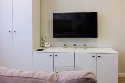 a white cabinet with a tv on top of it at Stilinga studija su visais patogumais in Šiauliai