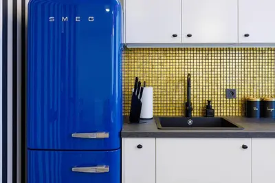 a blue refrigerator in a kitchen next to a sink at Stilinga studija su visais patogumais in Šiauliai