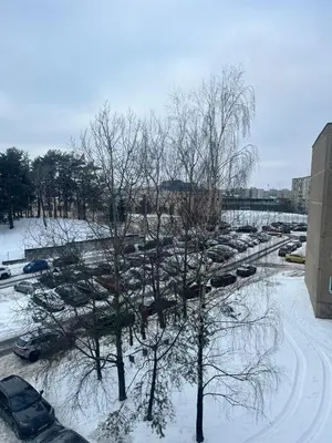 a parking lot with cars parked in the snow at Kerulis Apartments in Vilnius
