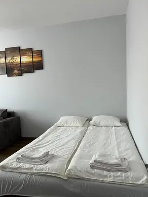 a bed with white sheets and towels on it at Kerulis Apartments in Vilnius