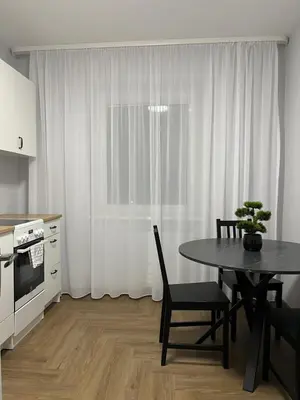 a kitchen with a table and chairs and a window at Kerulis Apartments in Vilnius