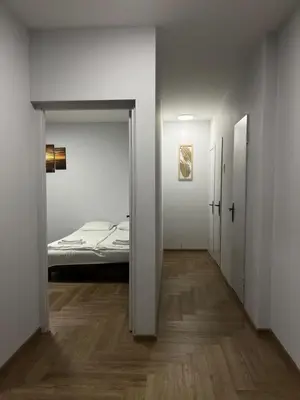 an empty room with a bed and a hallway with a door at Kerulis Apartments in Vilnius