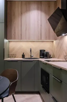 a kitchen with wooden cabinets and a sink at Cozy studio apartment in Kaunas