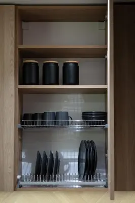 a cupboard with black bowls and plates in it at Cozy studio apartment in Kaunas