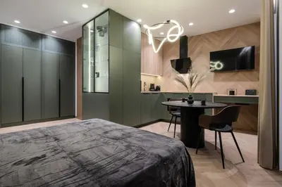 a bedroom with a bed and a desk and a table at Cozy studio apartment in Kaunas