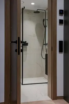 a shower with a glass door in a bathroom at Cozy studio apartment in Kaunas