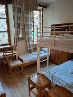 a room with two bunk beds and a table and chairs at Litinterp Host in Vilnius