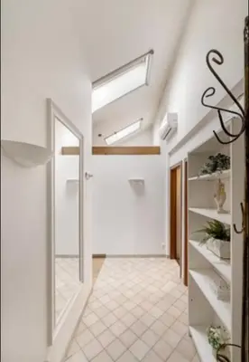 a hallway with white walls and a skylight at Cosy Place in Old Town in Vilnius