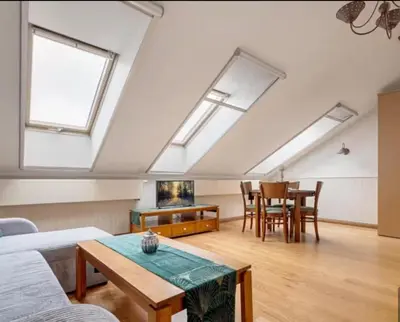 a living room with a table and some skylights at Cosy Place in Old Town in Vilnius