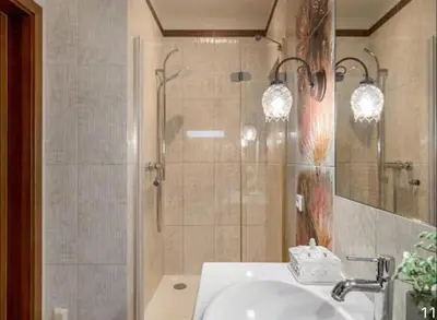 a bathroom with a shower and a sink and a mirror at Cosy Place in Old Town in Vilnius