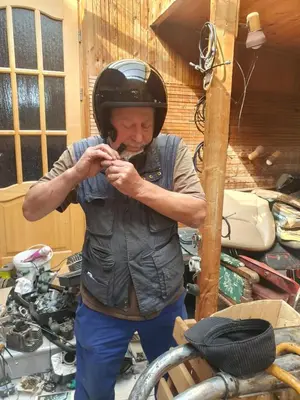 a man wearing a helmet while standing next to a motorcycle at Hostel in Rudamina
