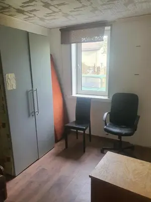 an empty room with two chairs and a window at Hostel in Rudamina