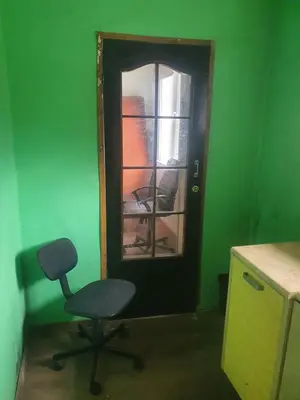 a door with a chair in a green room at Hostel in Rudamina