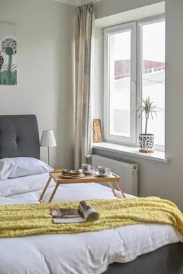 a bedroom with a bed with a table on it at Warm and Timeless- Authentic Vintage Living in Paupys in Vilnius