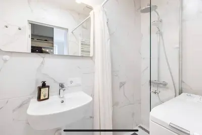 a white bathroom with a sink and a shower at Warm and Timeless- Authentic Vintage Living in Paupys in Vilnius