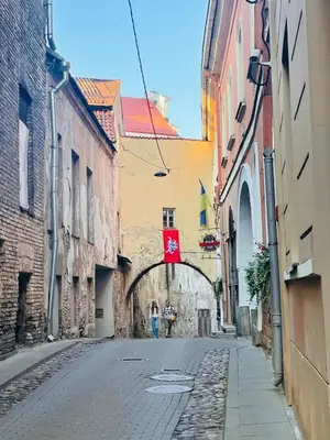 an alley with two people walking down a street at Warm and Timeless- Authentic Vintage Living in Paupys in Vilnius