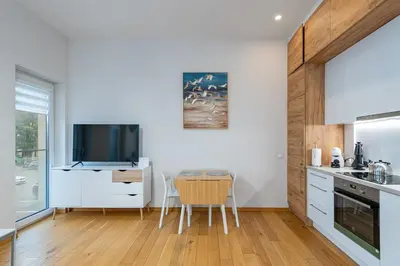 a kitchen with white cabinets and a table and chairs at Center apartment by Polo Apartments in Kaunas