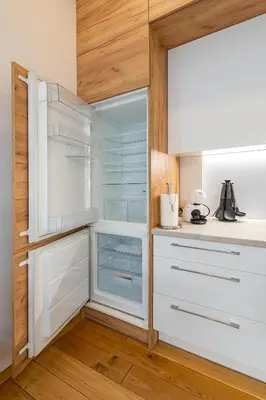 a kitchen with white cabinets and a glass refrigerator at Center apartment by Polo Apartments in Kaunas