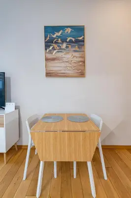 a dining room table with two chairs and a painting at Center apartment by Polo Apartments in Kaunas