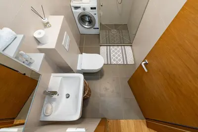 a bathroom with a sink and a washing machine at Center apartment by Polo Apartments in Kaunas