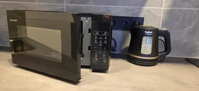 a microwave oven with a coffee mug next to it at Studio Ap in Visaginas