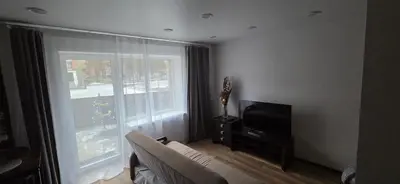 a living room with a couch and a television at Studio Ap in Visaginas