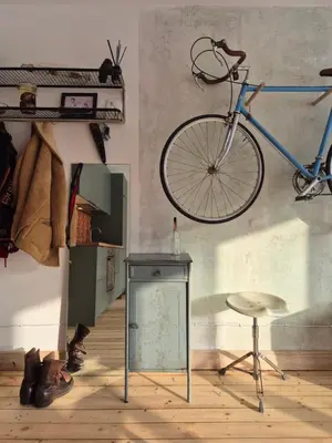 a bike hanging on a wall next to a chair at Nordhouse in Šiauliai