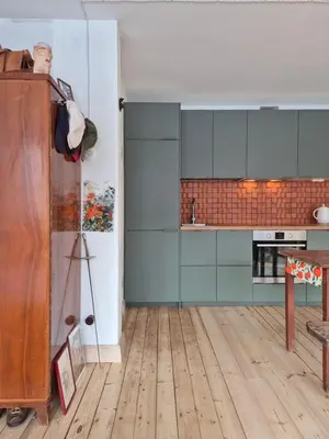 a kitchen with blue cabinets and a wooden floor at Nordhouse in Šiauliai