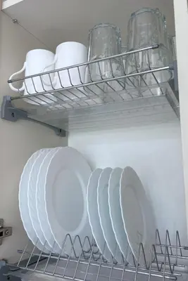 a group of plates and glasses on a shelf in a refrigerator at Old Town Riverside Cathedral Apartment in Vilnius