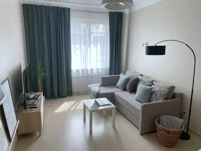 a living room with a couch and a table at Old Town Riverside Cathedral Apartment in Vilnius