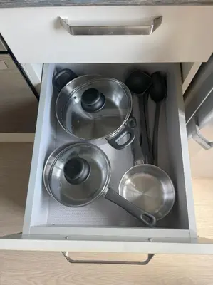 a drawer filled with pots and pans in a kitchen at Old Town Riverside Cathedral Apartment in Vilnius