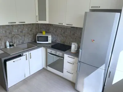a kitchen with white appliances and a refrigerator at Old Town Riverside Cathedral Apartment in Vilnius