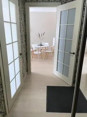 a hallway with a door and a dining room with a table at Old Town Riverside Cathedral Apartment in Vilnius