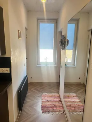 a room with two windows and a rug on the floor at Cozy and quiet apartment near the city in Kaunas