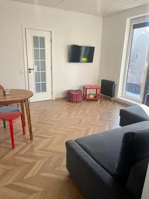 a living room with a couch and a table and a tv at Cozy and quiet apartment near the city in Kaunas