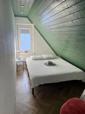 a bedroom with two beds with a wooden ceiling at Cozy and quiet apartment near the city in Kaunas