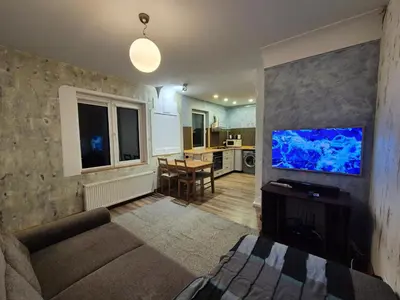 a living room with a couch and a blue aquarium at Valdau NT in Kaunas