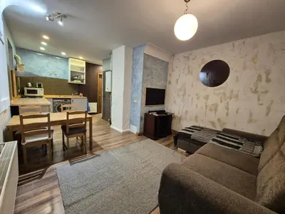 a living room and kitchen with a couch and a table at Valdau NT in Kaunas