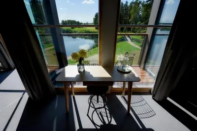 a table in a room with a large window at Barono Vila in Butėnai